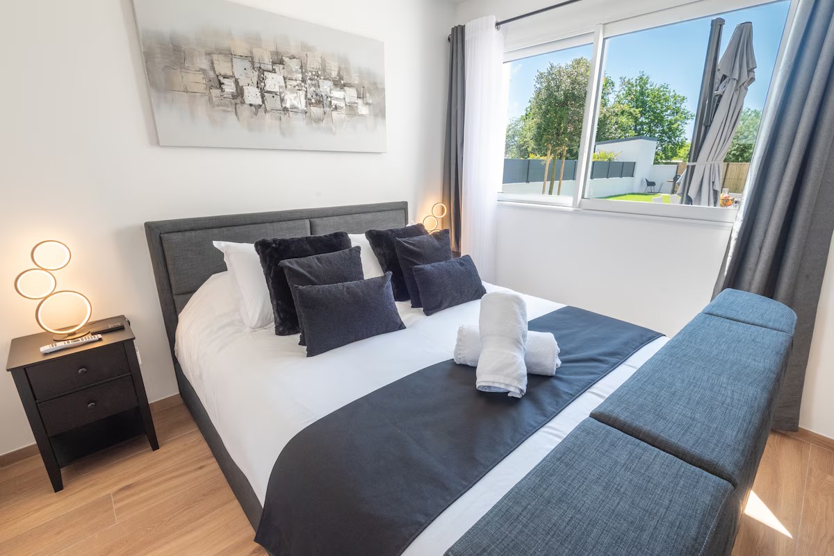 Chambre DOUBLE adaptée aux personnes à Mobilité Réduite PMR, RDJ, décoration contemporaine, lit 160, 2 types d'oreillers (moelleux et fermes) TV écran plat 4K rétractable dans le lit, un miroir en pied mural et rangements à disposition dans notre villa spacieuse située à Erdeven, 56 en Bretagne sud