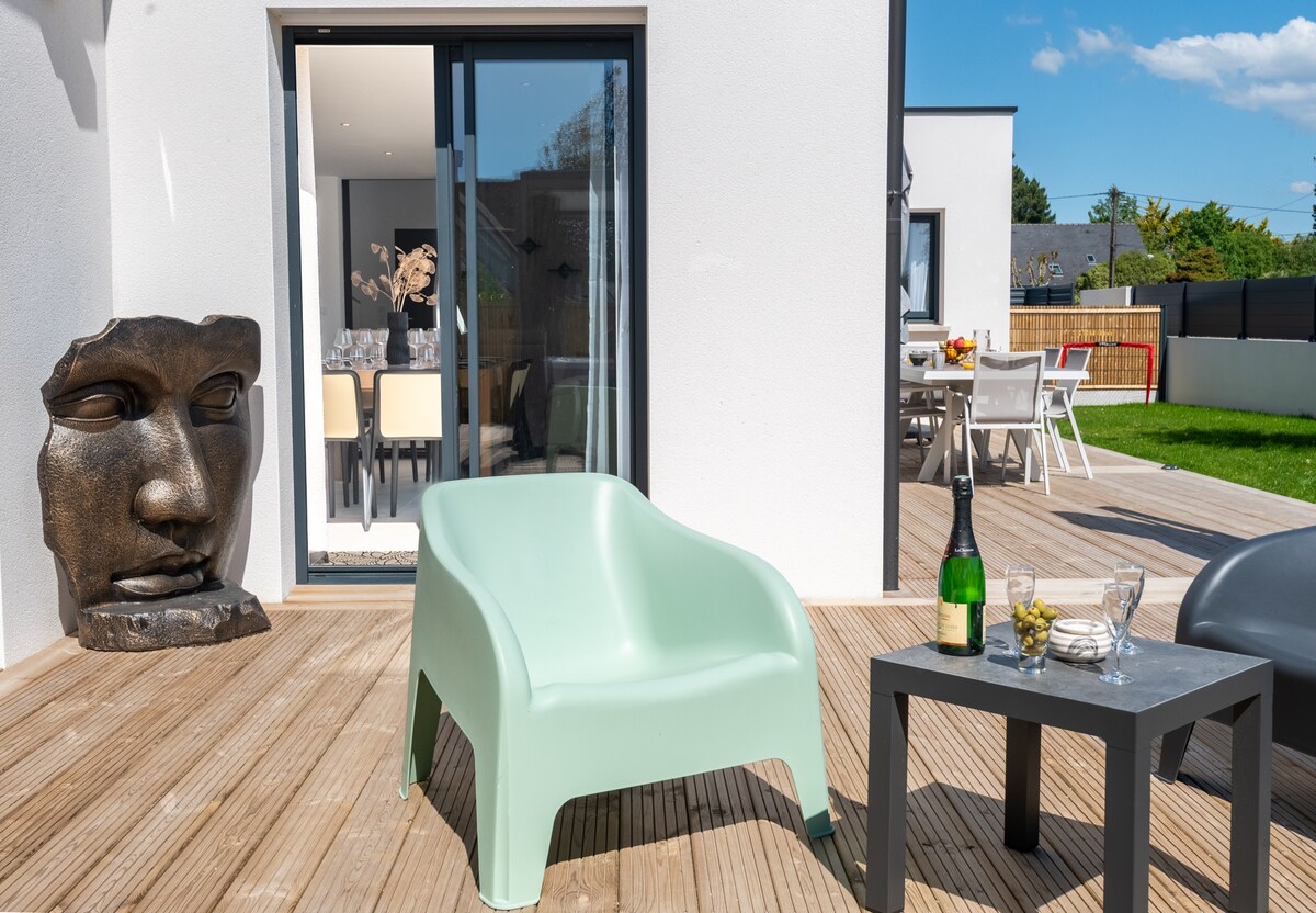 Villa à Erdeven dans le Morbihan ouverte sur le jardin et la terrasse de 90 m², équipée d’une table pour 10 personnes, deux grands parasols, un petit salon extérieur et un SPA. Les grandes baies vitrées donnent un accès direct sur le jardin et la terrasse qui sont visibles depuis toutes les pièces.